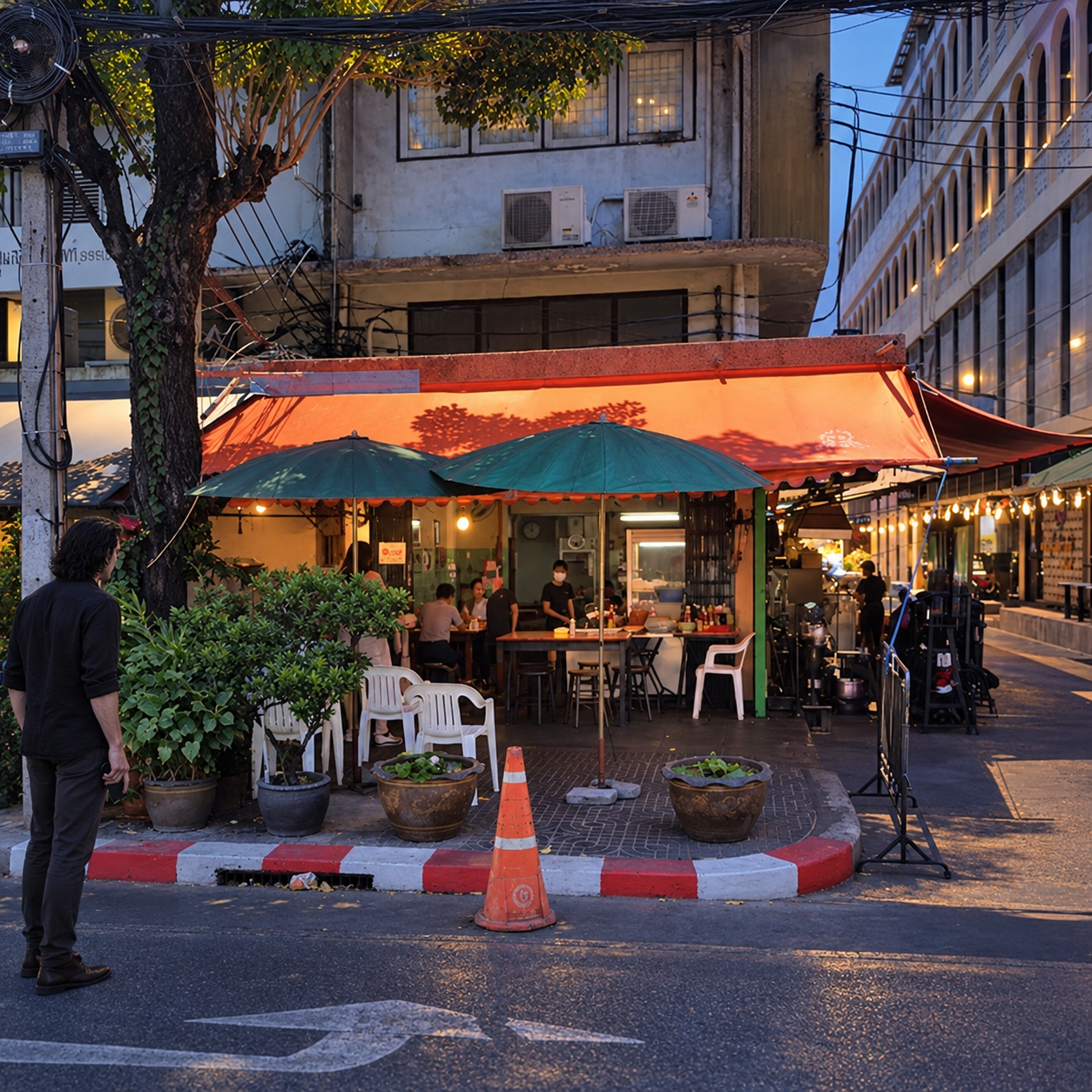 Vladimir pauses at a distance and looks toward Jay Fai in Bangkok at dusk